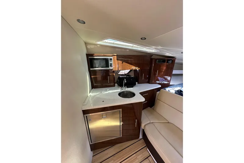 Just Traded Yacht Photos Pics Interior of 2014 Regal 35 Sport Coupe yacht with kitchenette and seating area.