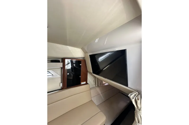 Just Traded Yacht Photos Pics Interior of 2014 Regal 35 Sport Coupe with TV and beige seating.