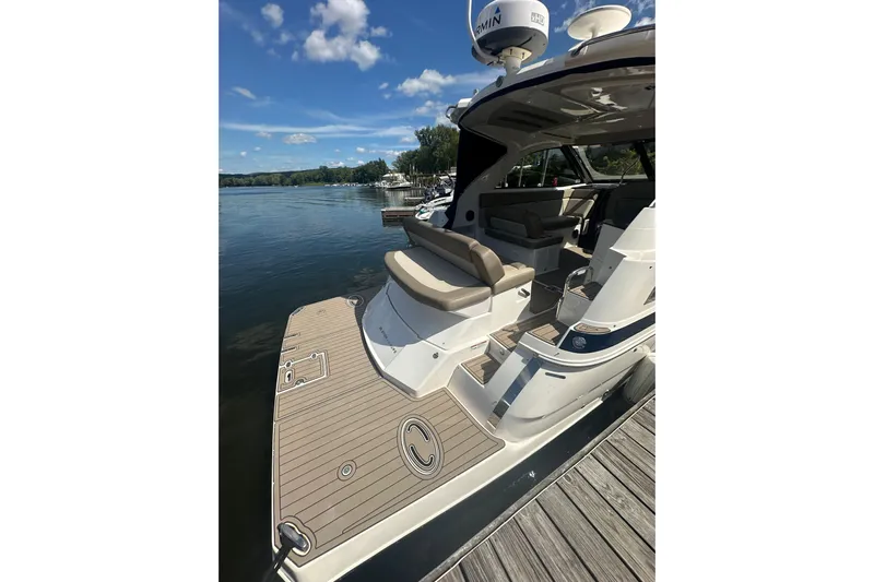 Just Traded Yacht Photos Pics 2014 Regal 35 Sport Coupe docked, showcasing spacious deck and seating under clear skies.