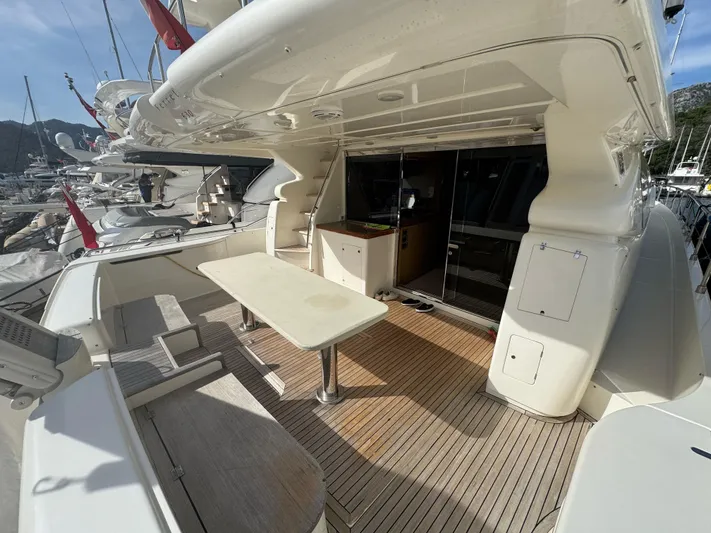  Yacht Photos Pics Luxurious 2007 Ferretti Yachts 630 deck with seating and table, docked at marina.