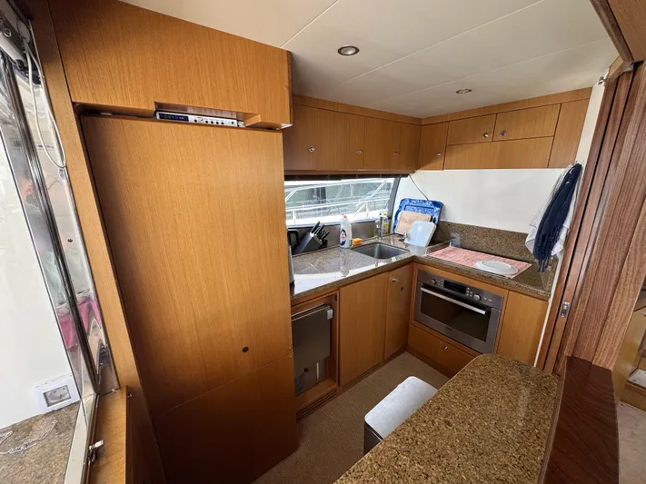  Yacht Photos Pics Luxurious kitchen interior of 2007 Ferretti Yachts 630 with modern appliances and wood cabinetry.