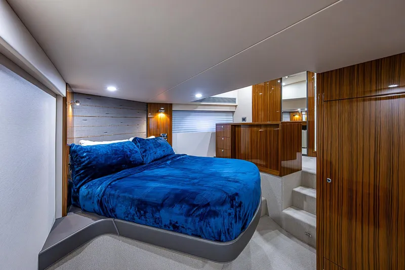 Tank Woo Yacht Photos Pics Luxurious bedroom interior of 2018 Maritimo M54 yacht with blue bedding and wooden accents.