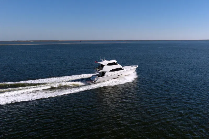 Tank Woo Yacht Photos Pics 2018 Maritimo M54 yacht cruising on open water under clear blue sky.