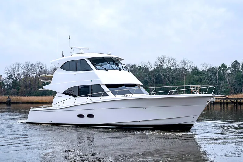 Tank Woo Yacht Photos Pics 2018 Maritimo M54 yacht cruising on a calm river with trees in the background.