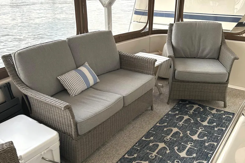 Fathom This Yacht Photos Pics Cozy seating area on 2001 Sea Ray 420 Aft Cabin with wicker furniture and nautical decor.