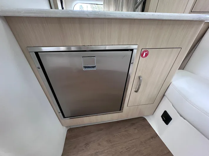 Sojourner Yacht Photos Pics 2024 Regal 33 XO interior with stainless steel fridge and wooden cabinetry.