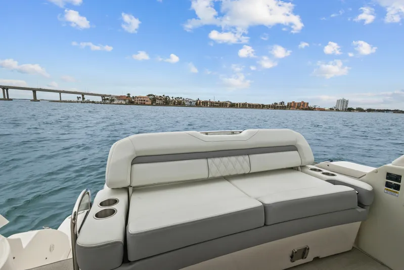 Sojourner Yacht Photos Pics 2024 Regal 33 XO boat with spacious seating, overlooking serene water and distant cityscape.