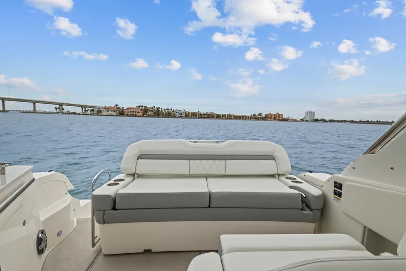 Sojourner Yacht Photos Pics 2024 Regal 33 XO boat interior with luxurious seating, overlooking serene water and distant shoreline.