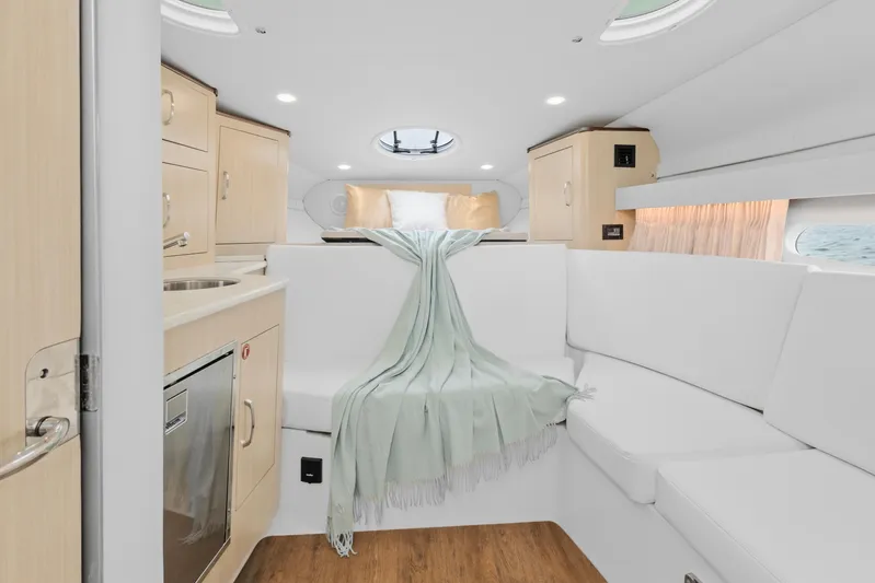 Sojourner Yacht Photos Pics 2024 Regal 33 XO yacht interior with modern white seating and light wood cabinetry.
