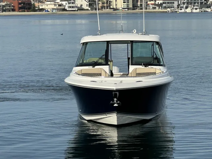 Always Grateful 2 Yacht Photos Pics 2021 Pursuit DC 326 Dual Console boat on calm water, with coastal buildings in the background.