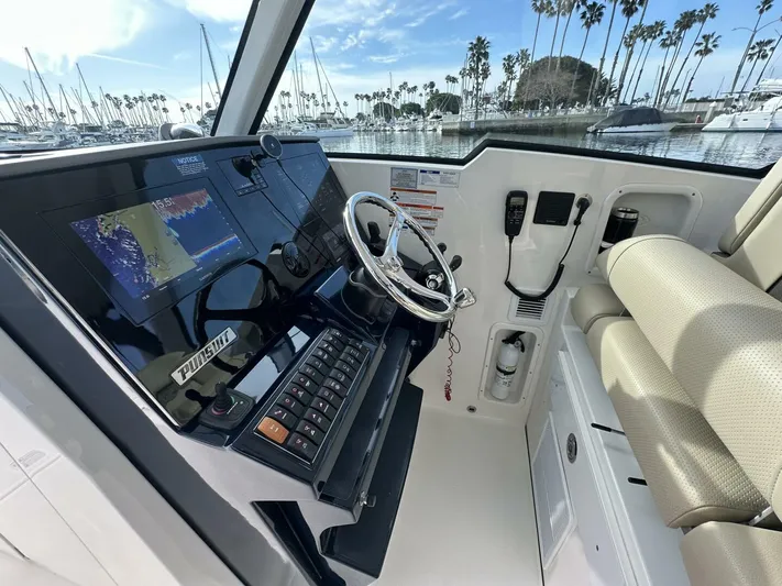Always Grateful 2 Yacht Photos Pics 2021 Pursuit DC 326 Dual Console boat interior with steering wheel and navigation system.