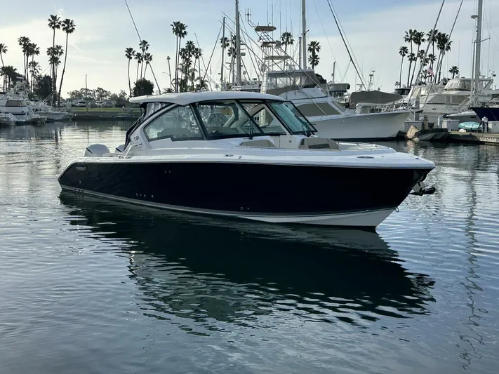 Always Grateful 2 Yacht Photos Pics 2021 Pursuit DC 326 Dual Console boat docked in a marina with palm trees.