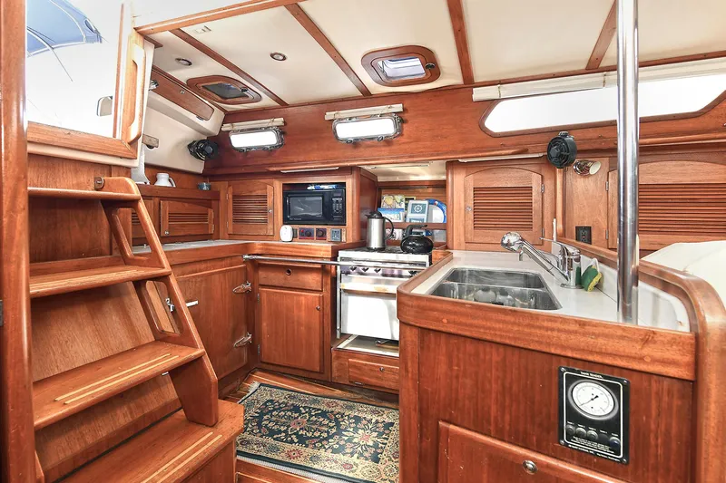 The Verdict III Yacht Photos Pics Luxurious Sabre 452 yacht interior kitchen, 2002 model, featuring wood cabinetry and modern appliances.