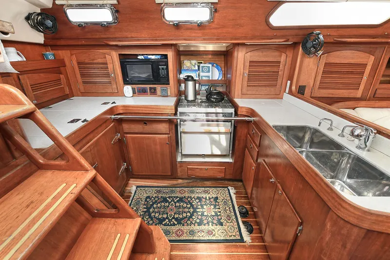 The Verdict III Yacht Photos Pics Luxurious 2002 Sabre 452 yacht kitchen with wood cabinetry and modern appliances.