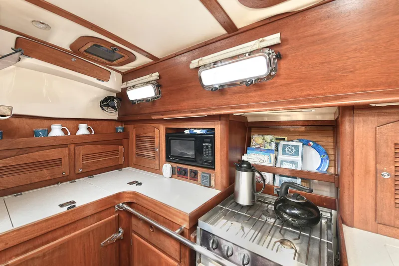The Verdict III Yacht Photos Pics 2002 Sabre 452 yacht kitchen with wooden cabinetry, stove, and microwave.