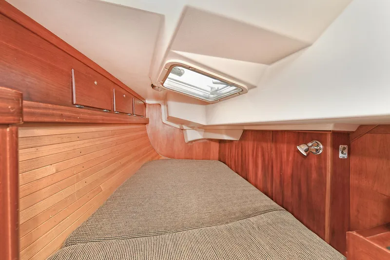The Verdict III Yacht Photos Pics Cozy cabin interior of 2002 Sabre 452 sailboat with wood paneling and bedding.