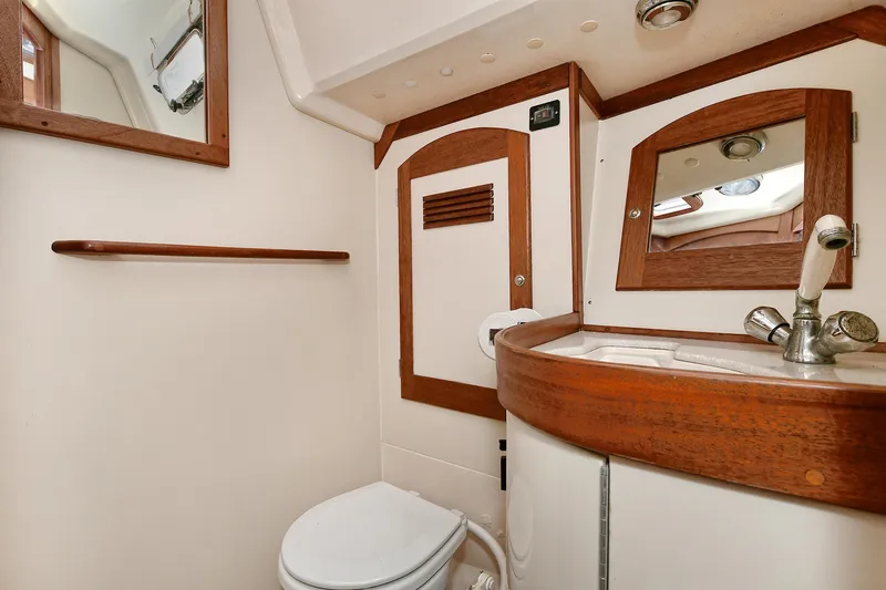 The Verdict III Yacht Photos Pics 2002 Sabre 452 yacht bathroom with wooden accents and modern fixtures.