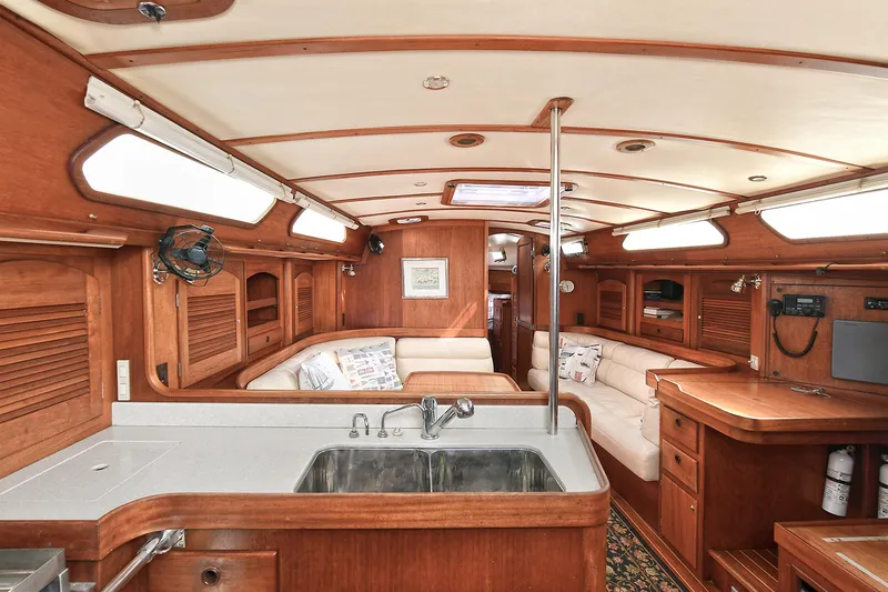 The Verdict III Yacht Photos Pics Interior of 2002 Sabre 452 sailboat with wooden cabinetry and cozy seating area.