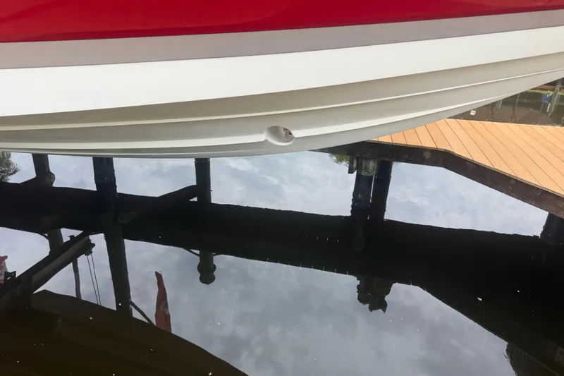  Yacht Photos Pics 2007 Cobalt 343 boat hull reflecting on calm water near a wooden dock.