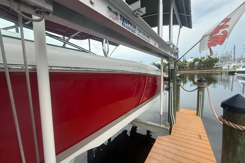  Yacht Photos Pics Red 2007 Cobalt 343 boat docked on a lift at a marina.