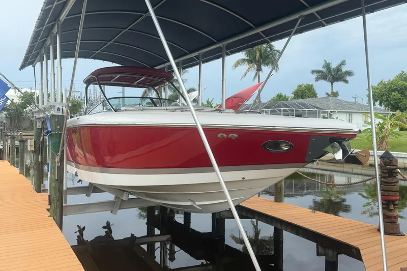  Yacht Photos Pics Red 2007 Cobalt 343 boat docked under a canopy, surrounded by tropical scenery.