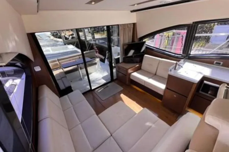  Yacht Photos Pics Luxurious interior of 2016 Sea Ray 400 Sundancer yacht with modern seating and large windows.