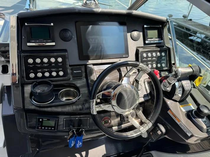  Yacht Photos Pics Control panel of a 2019 Monterey 335 SY boat with steering wheel and navigation equipment.