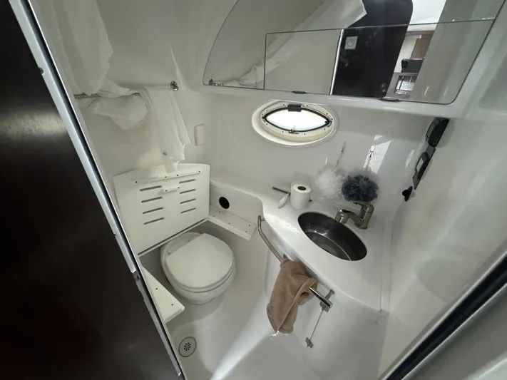  Yacht Photos Pics 2019 Monterey 335 SY boat bathroom with toilet, sink, and porthole window.