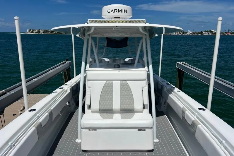  Yacht Photos Pics 2023 Contender 39 ST boat docked, featuring Garmin equipment, with ocean and island backdrop.