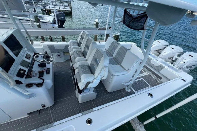  Yacht Photos Pics 2023 Contender 39 ST boat interior with seating and control panel, docked by the water.