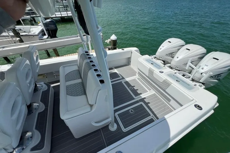  Yacht Photos Pics 2023 Contender 39 ST boat with triple Yamaha engines, docked on clear water.