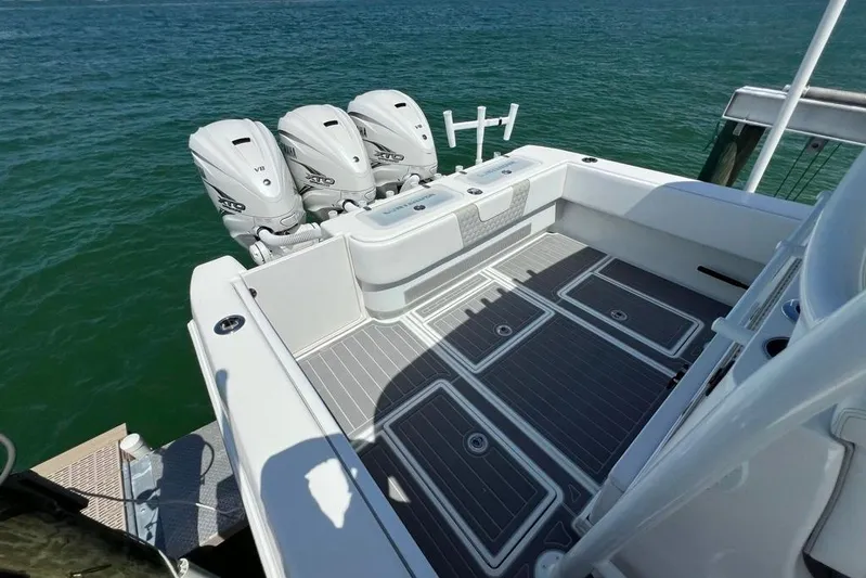  Yacht Photos Pics 2023 Contender 39 ST boat with triple outboard engines on calm water.