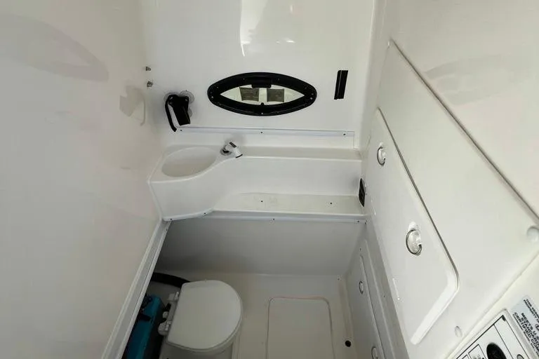  Yacht Photos Pics 2023 Contender 39 ST boat interior bathroom with sink, toilet, and oval window.