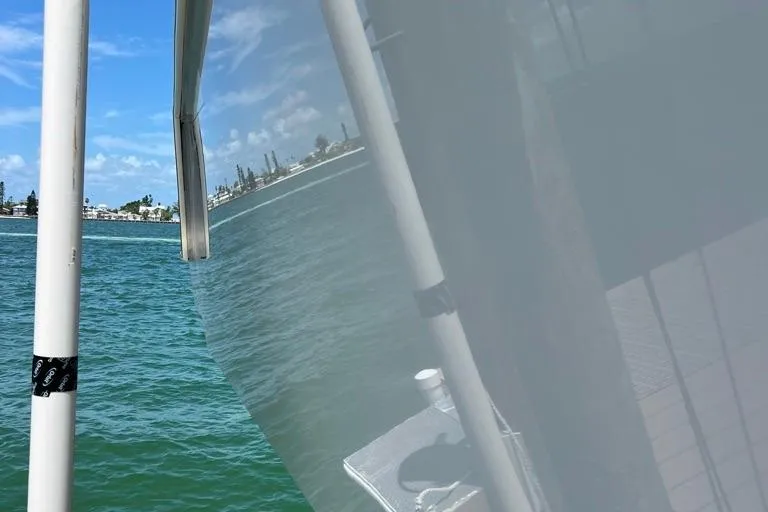  Yacht Photos Pics 2023 Contender 39 ST boat on water, reflecting coastal scenery.