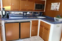 2011 Cabo Express 40 yacht kitchen with wooden cabinets, blue countertops, and modern appliances.