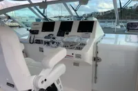 Helm of 2011 Cabo Express 40 yacht with modern navigation equipment and white captain's chair.