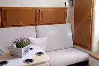 2011 Cabo Express 40 interior with white seating, wooden cabinets, and a small table.