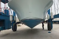 2011 Cabo Express 40 boat in dry dock, front view, with blue lift equipment.