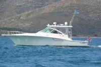 2011 Cabo Express 40 yacht cruising on blue waters with mountainous backdrop.