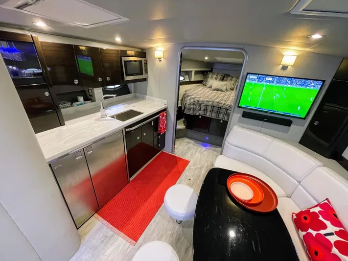 Nauti Dog II Yacht Photos Pics Modern interior of 2021 Formula 40 PC yacht with kitchen, seating area, and TV.
