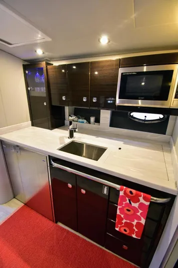 Nauti Dog II Yacht Photos Pics Modern kitchen area in 2021 Formula 40 PC yacht with sleek cabinetry and appliances.
