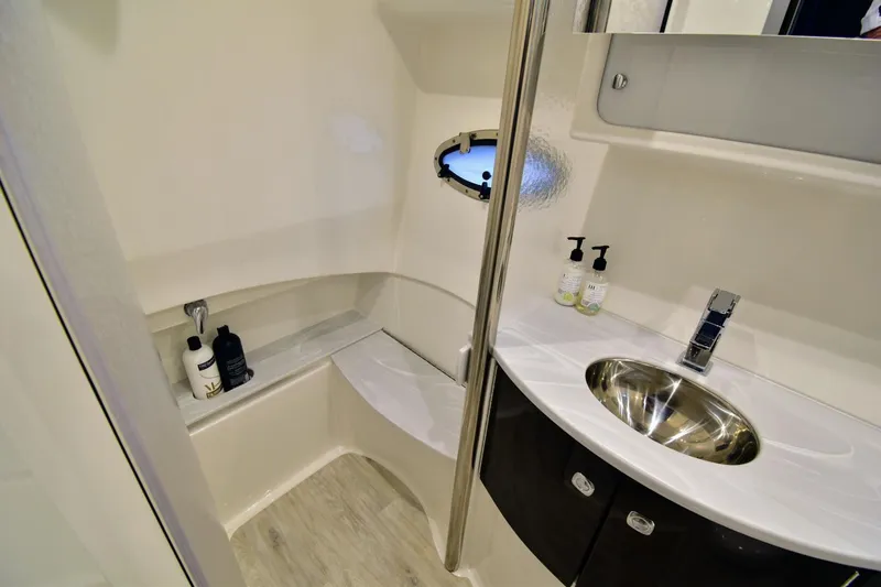 Nauti Dog II Yacht Photos Pics 2021 Formula 40 PC yacht bathroom with sink, mirror, and porthole window.