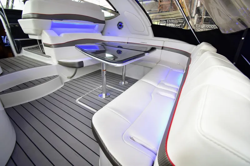 Nauti Dog II Yacht Photos Pics 2021 Formula 40 PC yacht interior with white leather seating and modern table.