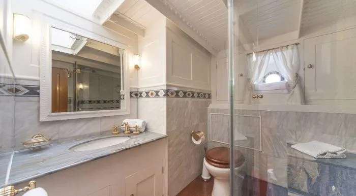 Puritan Yacht Photos Pics Elegant 1931 schooner bathroom with marble countertop, glass shower, and nautical decor.