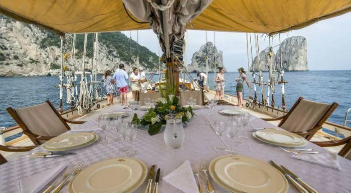 Puritan Yacht Photos Pics Elegant dining setup on 1931 Schooner sailboat with scenic ocean view.