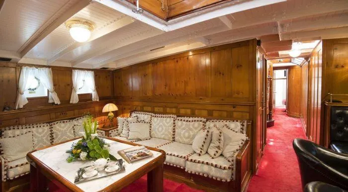 Puritan Yacht Photos Pics Luxurious 1931 Schooner sailboat interior with wooden paneling and elegant seating area.
