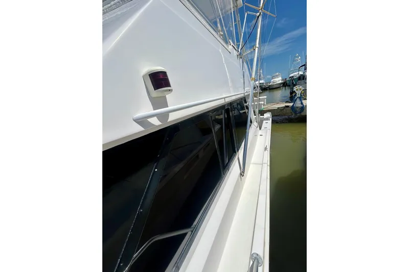  Yacht Photos Pics 1990 Viking 48 Convertible yacht docked, showcasing sleek white exterior and marina view.