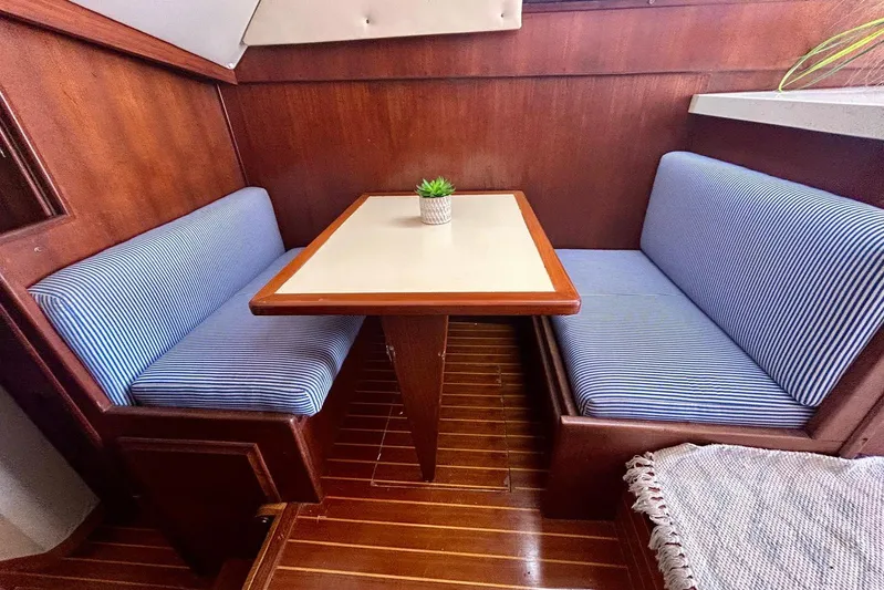  Yacht Photos Pics 1990 Viking 48 Convertible interior with striped seating and wooden table.