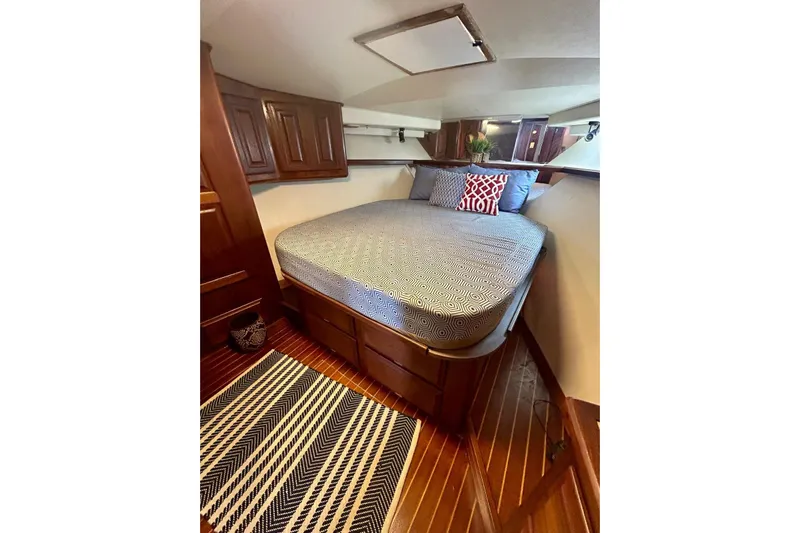  Yacht Photos Pics Cozy bedroom in 1990 Viking 48 Convertible yacht with patterned bedding and wooden cabinetry.