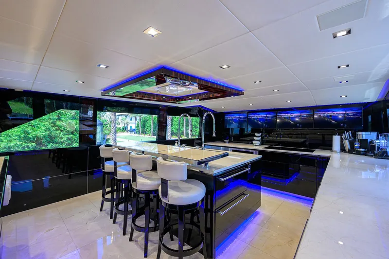  Yacht Photos Pics Luxurious interior of 1997 Broward 108 Raised Pilothouse yacht with modern kitchen and bar stools.